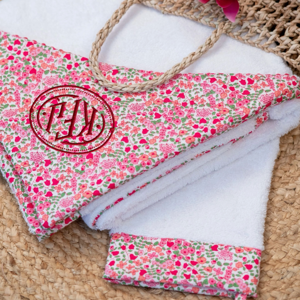 Floral-patterned bag with monogram on a woven surface