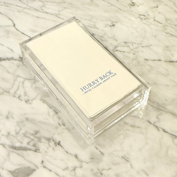 Clear plastic box with 'Hurry Back' text on a marble surface
