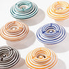 Set of six striped ceramic ashtrays on a white background