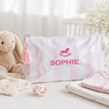 Pink pouch with 'SOPHIE' printed on it, next to a plush bunny and baby items on a light surface.
