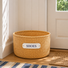 Wicker shoe storage basket with a 'SHOES' label on a wooden floor.