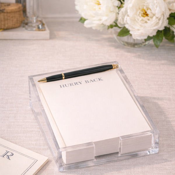 Notebook with a pen and flowers on a light surface