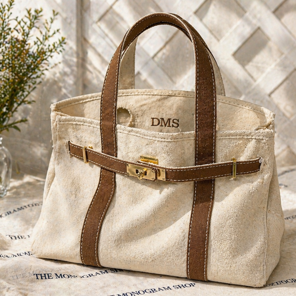 Beige handbag with brown straps on a surface with text