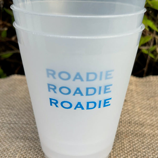 A set of shatterproof plastic cups with 'ROADIE' printed on them, packaged in clear plastic, with each cup tied with a ribbon in different colors.