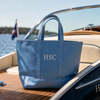 Blue tote bag with 'HSC' monogram on a boat