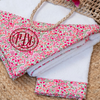 Floral-patterned bag with monogram on a woven surface