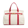 White tote bag with red straps and trim on a white background