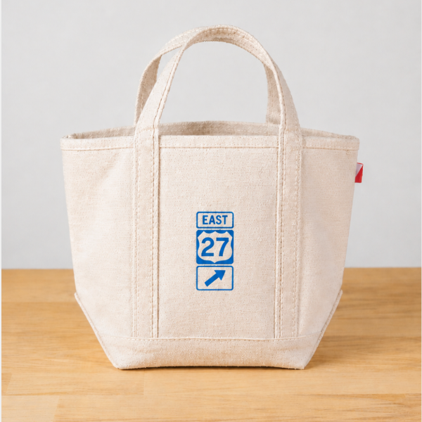 Beige tote bag with a blue and white logo on a wooden surface