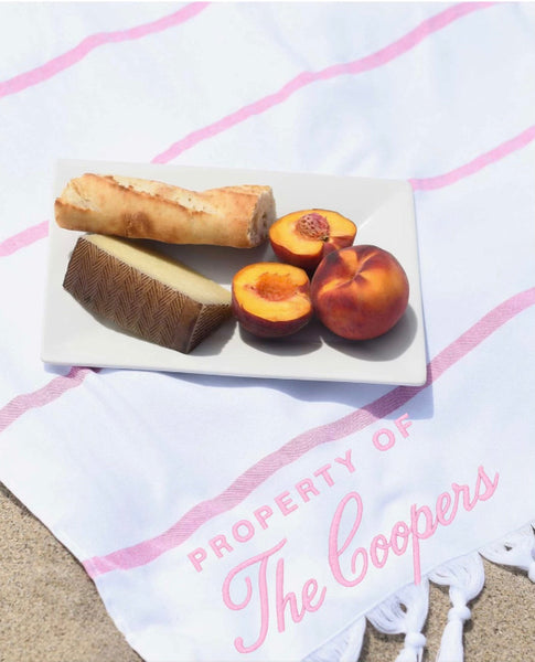 Fruit platter with peaches and a loaf of bread on a towel with 'Property of The Coopers' text.