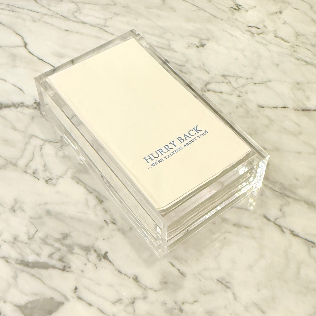 Clear plastic box with 'Hurry Back' text on a marble surface