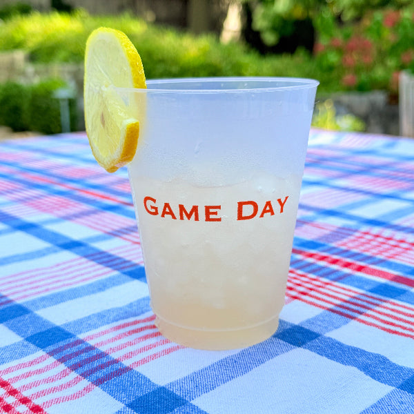 White cup with 'GAME DAY' text, lemon slice, and plaid fabric background