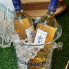 Two bottles of wine in an ice bucket with 'Summer' text on a grassy background